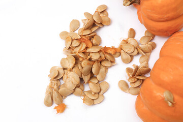Broken pumpkin with seeds on white background