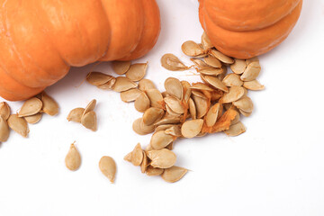 Broken pumpkin with seeds on white background