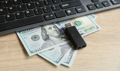 USB flash drive with hundred dollar bills and keyboard on table. Online business, crypto trading concept