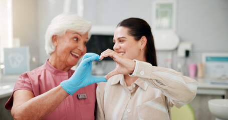 Woman, dentist and heart hands at clinic, smile and gratitude with good service for oral care. Mature person, orthodontist and patient with love emoji, sign or happy with dental health at hospital