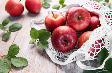 Fresh red apples resting in reusable shopping bag promoting sustainability