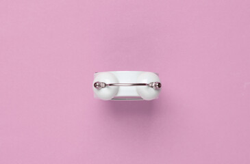 Top view of alarm clock bell on pink background