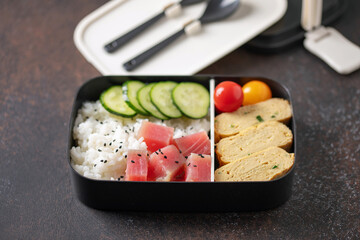 Asian bento box with rice, tuna, omelette tamagoyaki and vegetables. Healthy snack in the office or school