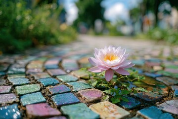 Vibrant Water Lily Blooming on Colorful Mosaic Pathway Surrounded by Lush Greenery in Bright Natural Light Under a Clear Blue Sky
