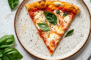 Closeup of margherita pizza slice with fresh basil on textured plate, overhead view