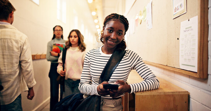 Student, girl and phone in corridor at high school for text message, social media or online portal for assessment. Female person, teenager and mobile app for academic communication or email on campus