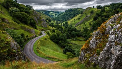 Fototapeta premium Scenic winding road through a lush valley under a dramatic sky