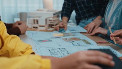 A dynamic scene shows architects engaged in a thoughtful discussion over detailed blueprints and architectural models, illustrating collaboration in design and planning. SACTR