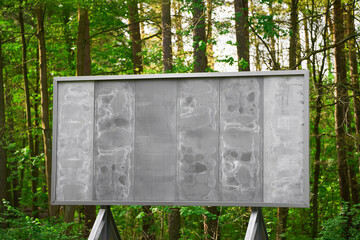 Large blank billboard in forest perfect for business campaigns