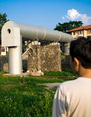 Child gazes at futuristic metal pipeline