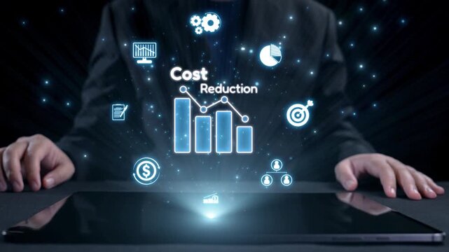 A businessman sits at a dark table, analyzing a digital tablet displaying vibrant icons and graphs that symbolize cost reduction and financial strategies in a modern office setting. Qubit