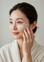 Radiant Beauty Ritual: A woman delicately applies a skincare product to her face, capturing a moment of self-care and beauty.