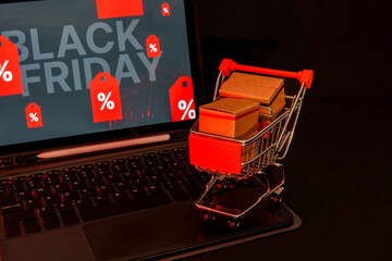 Shopping cart full of cardboard boxes on laptop keyboard showing black friday deals