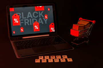 Black friday online shopping with laptop and miniature cart