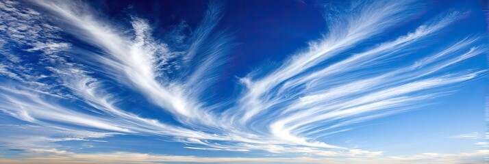 Wispy, flowing clouds against a vibrant blue sky