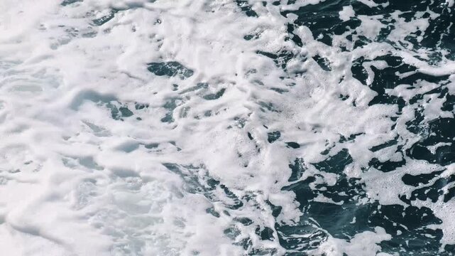 White sea foam covers the turquoise surface of the Adriatic in Budva, Montenegro. Horizontal 4k footage
