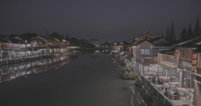 Charming Waterfront View of Illuminated Shops Amidst Calm Waters. Zhujiajiao, Shanghai, China