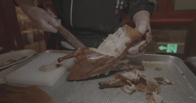 chef skillfully Peking duck slices succulent meat for an eager crowd, showcasing expertise.