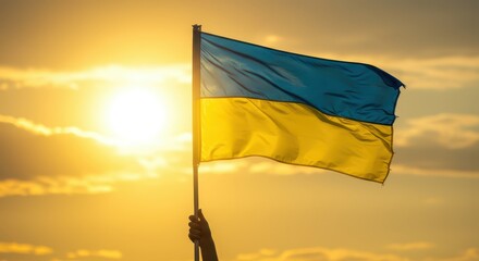 Fototapeta premium Ukrainian flag: The Ukrainian flag, a symbol of national pride and resilience, waves proudly against the backdrop of a brilliant sunset.