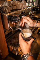 Barista steaming milk at stylish coffee shop in the centre of Bangkok
