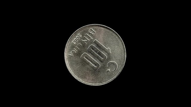 Turkish 100 Bin Lira coin from 2003 rotating against a pure black background with copy space