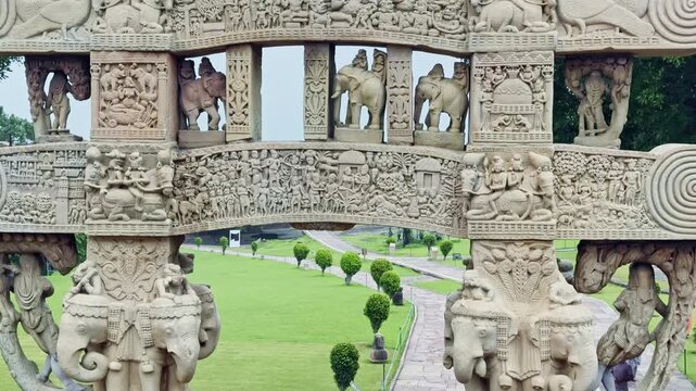 As the camera tilts up, the Torana of Sanchi Stupa unfolds from elephant-carved bases to upper panels, revealing detailed carvings of processions, animals, and sacred symbols of Buddhist heritage.