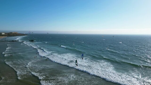 Aerial view of people kite surfing at the Guincho beach, windy day in Portugal