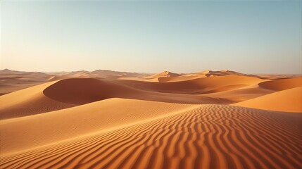 Breathtaking panoramic view of undulating golden sand dunes with textured ripples under a clear, serene blue sky in an expansive desert
