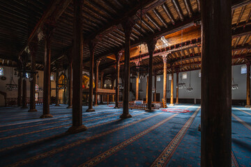 The interior of Esrefoglu Mosque in Konya Beysehir with its wooden columns and carpets