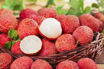 Fresh Hainan Lychee Fruit in Wicker Basket on Wooden Table - Sweet Tropical Asian Delicacy
