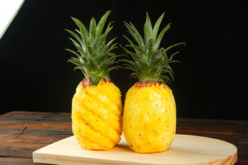Fresh Golden Hainan Pineapples with Diamond Cut Pattern and Handpulled Flesh on Wooden Board