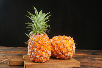 Fresh Golden Hainan Pineapples with Diamond Pattern on Wooden Board - Premium Tropical Fruit Display