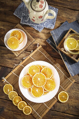 Making Dried Orange Fruit Slices for Tea on Rustic Wooden Table with Traditional Teapot