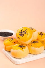 Traditional Egg Custard Pastries with Black Sesame Seeds on Marble Board - Asian Bakery Desserts