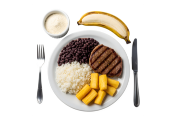 A plate filled with rice, beans, steak, and cassava. Plus some cutlery, manioc flour, and a banana for dessert. Set against a white wooden background
