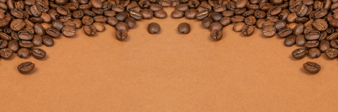 Dark brown whole coffee beans on wood background with copyspace