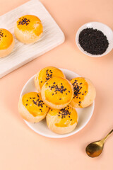 Golden Glazed Pastries with Black Sesame Seeds - Handmade Asian Desserts on Peach Background