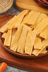 Dried Tofu Skin Bean Curd Sheets on Wooden Plate - Traditional Asian Soybean Food Product