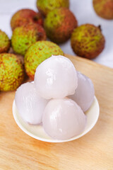 Fresh Hainan Litchi Fruits Peeled and Displayed in White Bowl with Tropical Asian Lychee Background