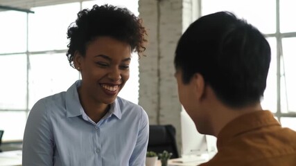 Happy African American woman shaking hands with Asian man, meeting at business office. Diverse team at work, successful partnership and collaboration. - Powered by Adobe