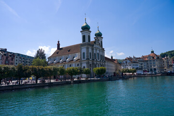 Fototapeta premium Scenic view of Reuss River and Jesuit Church at Swiss city of Luzern on a sunny summer day. Photo taken August 25th, 2025, Lucerne, Switzerland.