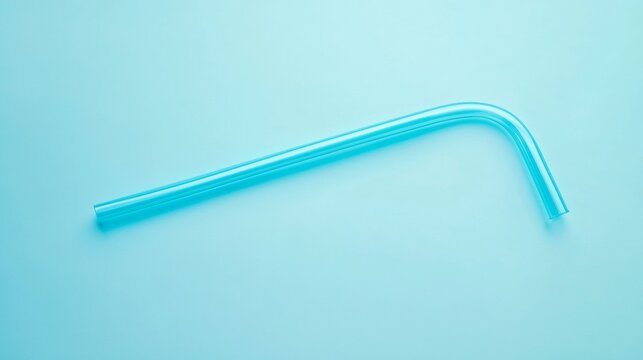 A flexible plastic straw bent at the neck laying flat on a solid pale blue background nostalgic retro feeling simple everyday 