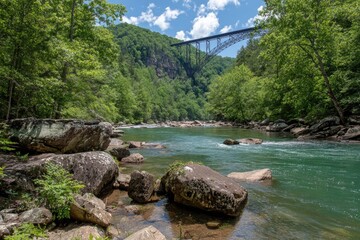 River flows through lush green valley, large rocks on riverbank, steel bridge visible in distance