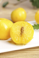 Fresh Golden Apricots Cut in Half on White Plate with Shallow Depth of Field