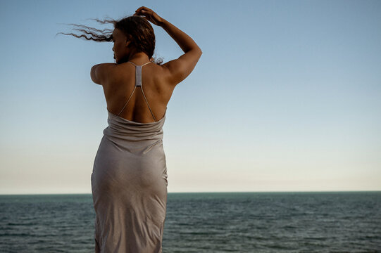 African American woman on the seashore, back to the camera