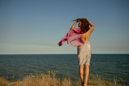 African American woman on the seashore, back to the camera