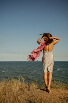 African American woman on the seashore, back to the camera