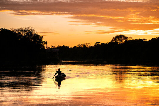 Beautiful sunrise view to local amazon indigenous man canoeing