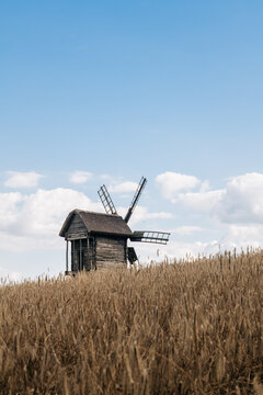 Wooden windmill in wheat field