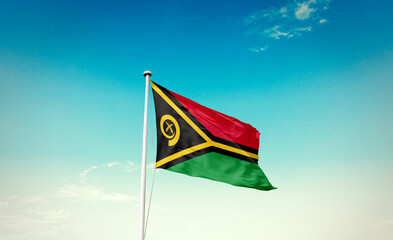 Vanuatu flag waving in blue sky with mast.